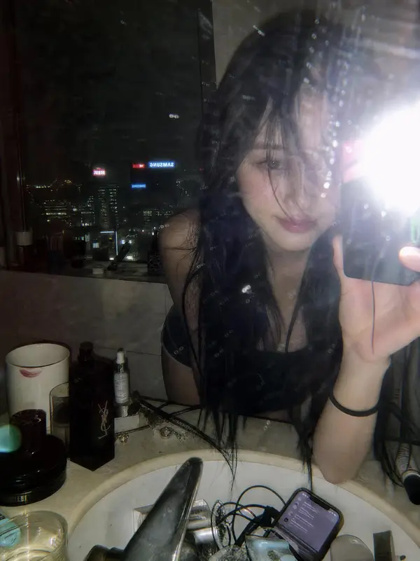 A moody late-night mirror selfie in a luxury high-rise bathroom with a glowing… — GPT Image 2 prompt by @iamaiistudio