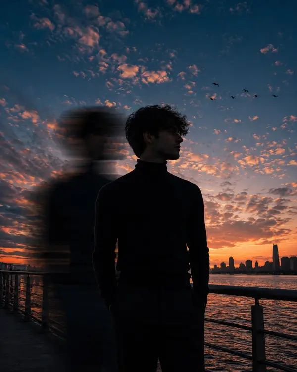 A cinematic low-angle portrait of a young man standing on a waterfront… — GPT Image 2 prompt by @harboriis