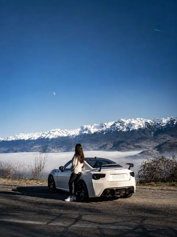 Ultra-realistic cinematic travel photography of a white sports coupe parked at… — AI Model prompt by @oju689