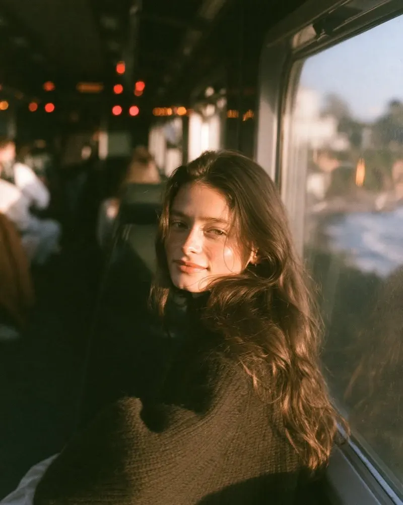 Ultra-cinematic golden hour portrait of a beautiful young woman sitting by the… — GPT Image 2 prompt by @Taaruk_