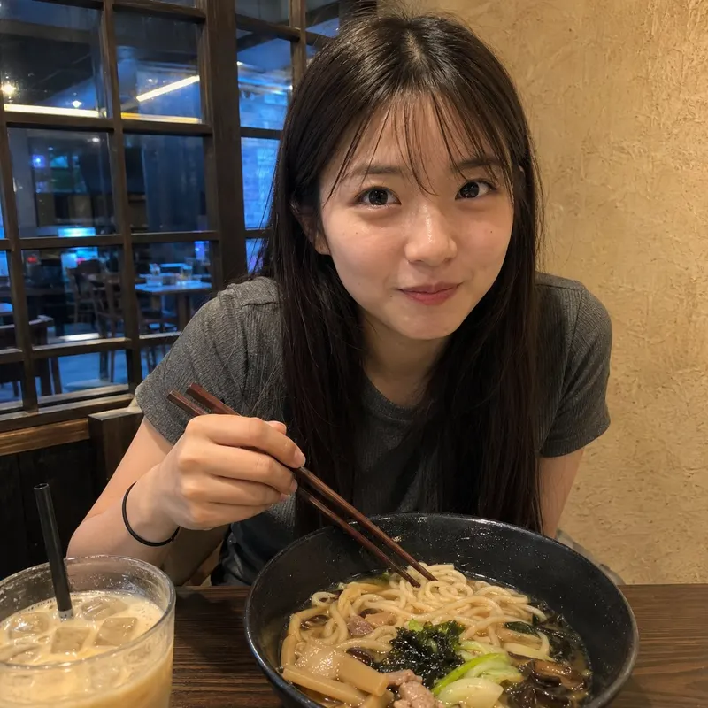 生成一张 1:1 比例的超写实手机随拍照片。一位二十多岁的漂亮东亚女生坐在温暖安静的日式餐厅里吃面，身体稍微前倾，正面看向镜头。她有自然清秀的圆润鹅蛋脸、白皙真… — GPT Image 2 prompt by @johnAGI168