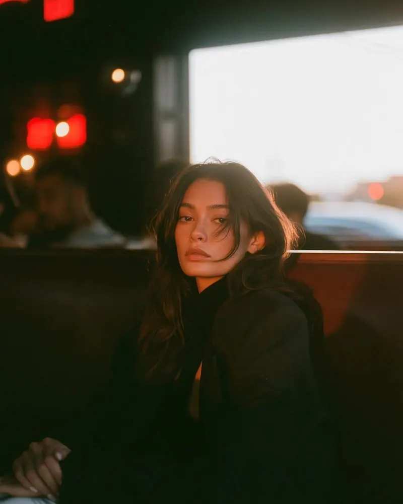 A cinematic café portrait of a beautiful young woman sitting alone in a cozy… — GPT Image 2 prompt by @Taaruk_